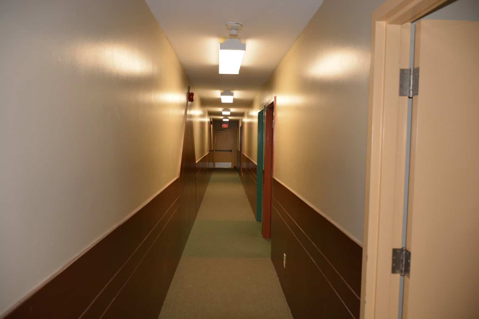 Bright hallway inside a modern camp building at Camp Arnes with beige walls and overhead lighting.