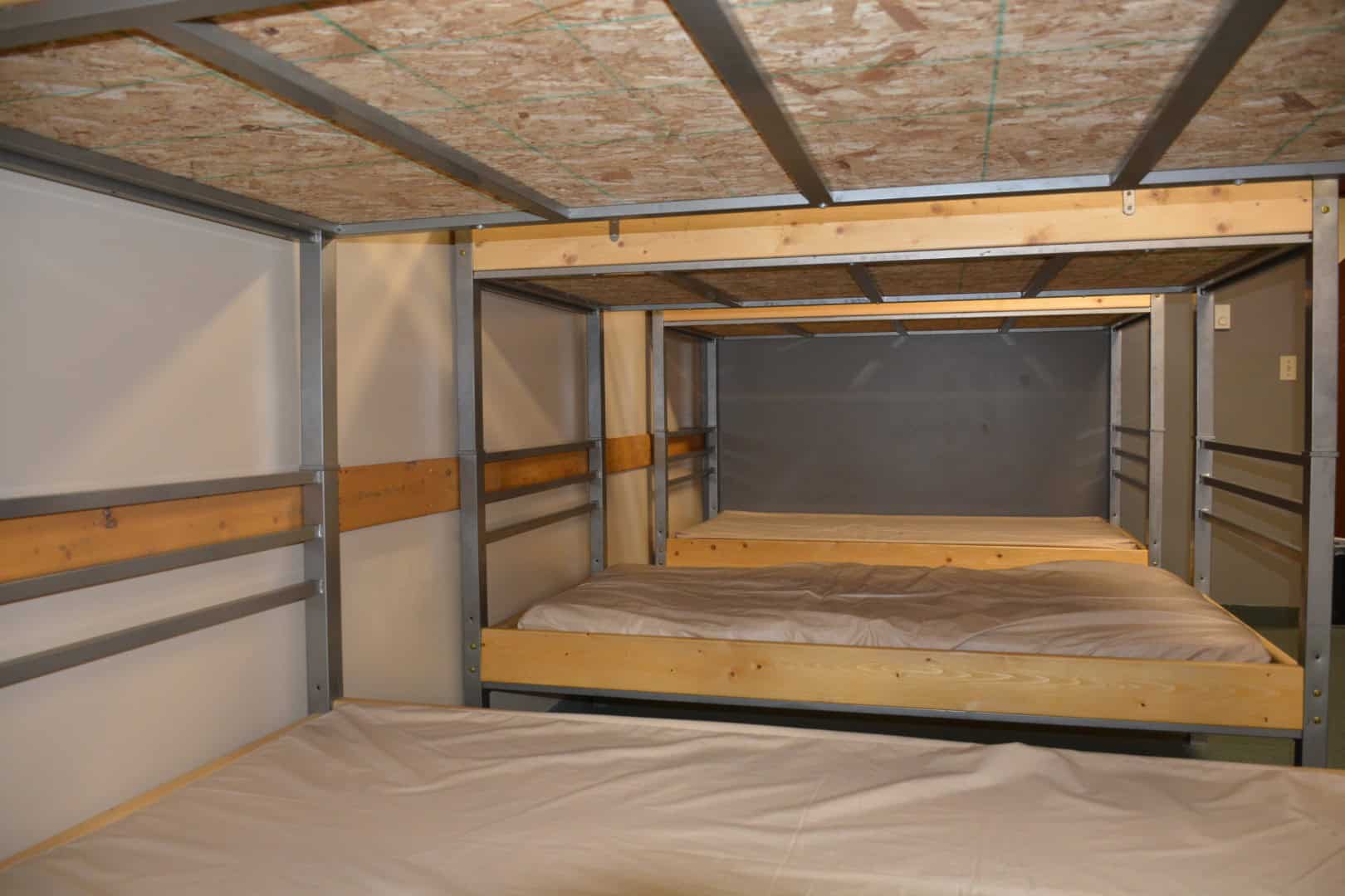 Bunk bed construction at Camp Arnes with metal frame and wooden beds, ideal for group lodging and outdoor camping accommodations.