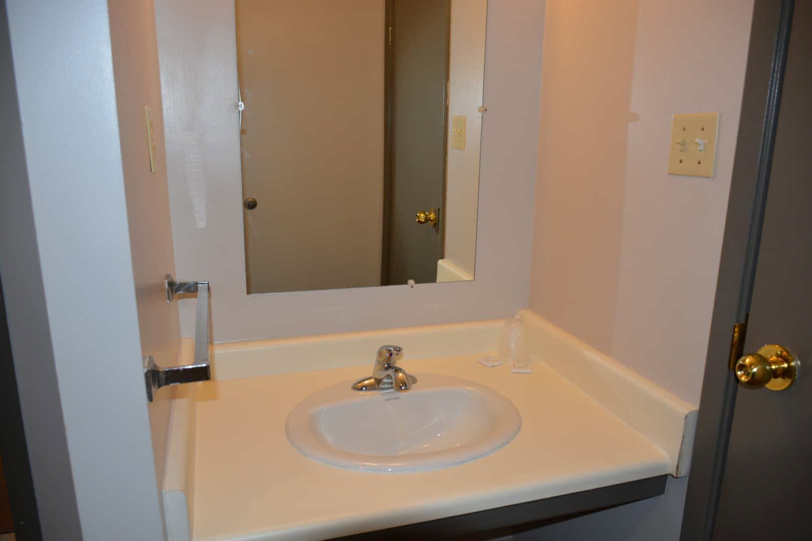 Bathroom sink with mirror at Camp Arnes campgrounds, featuring simple fixtures and clean design. Perfect for relaxing and outdoor adventures at Camp Arnes.