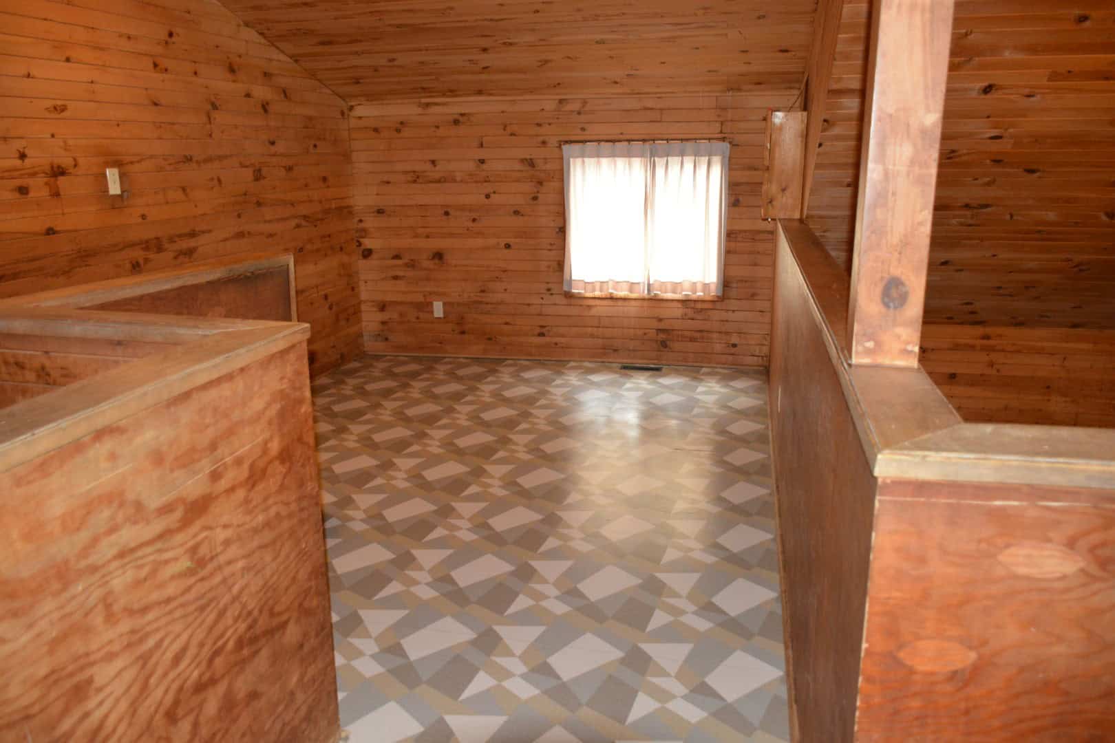 Cozy wooden cabin interior at Camp Arnes, featuring warm wood paneling and a patterned vinyl floor, ideal for relaxing family getaways and outdoor adventures in Manitoba.